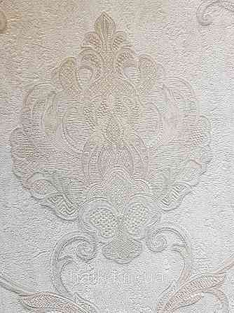 Шпалери вінілові на флізеліні Grandeco Anastasia метрові вензелю завитки структурні сріблясті на білому Київ